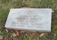 A grave stone with a cross on it

Description automatically generated